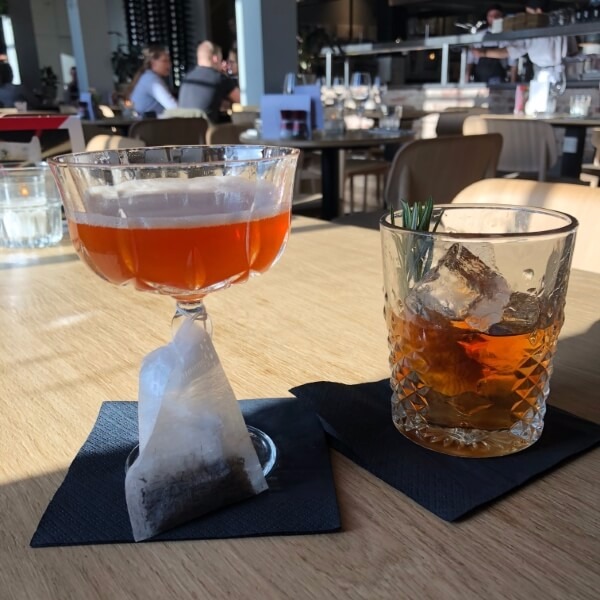 2 glazen op tafel met tea en een drunken mel cocktail in Utrechts restaurant