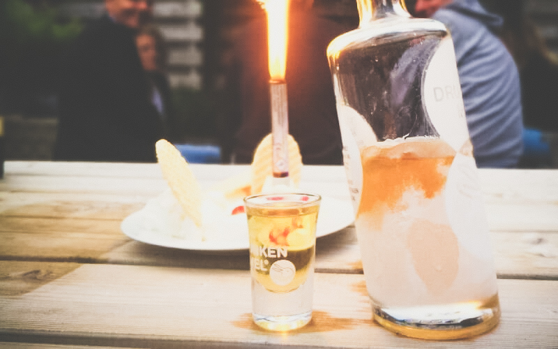 Bevroren Drunken Mel fles half vol met een kaars of vuurwerk ernaast