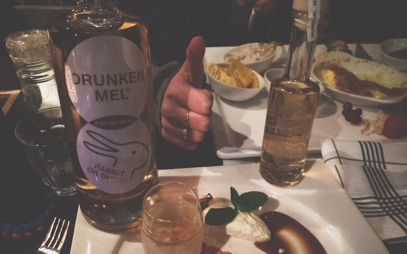 Tafel met gerechten en een fles drunken Mel