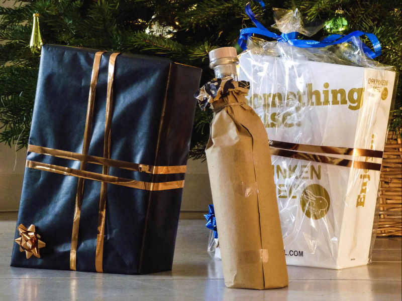 1 fles en 2 kerst relatie verpakkingen op de grond onder de kerstboom